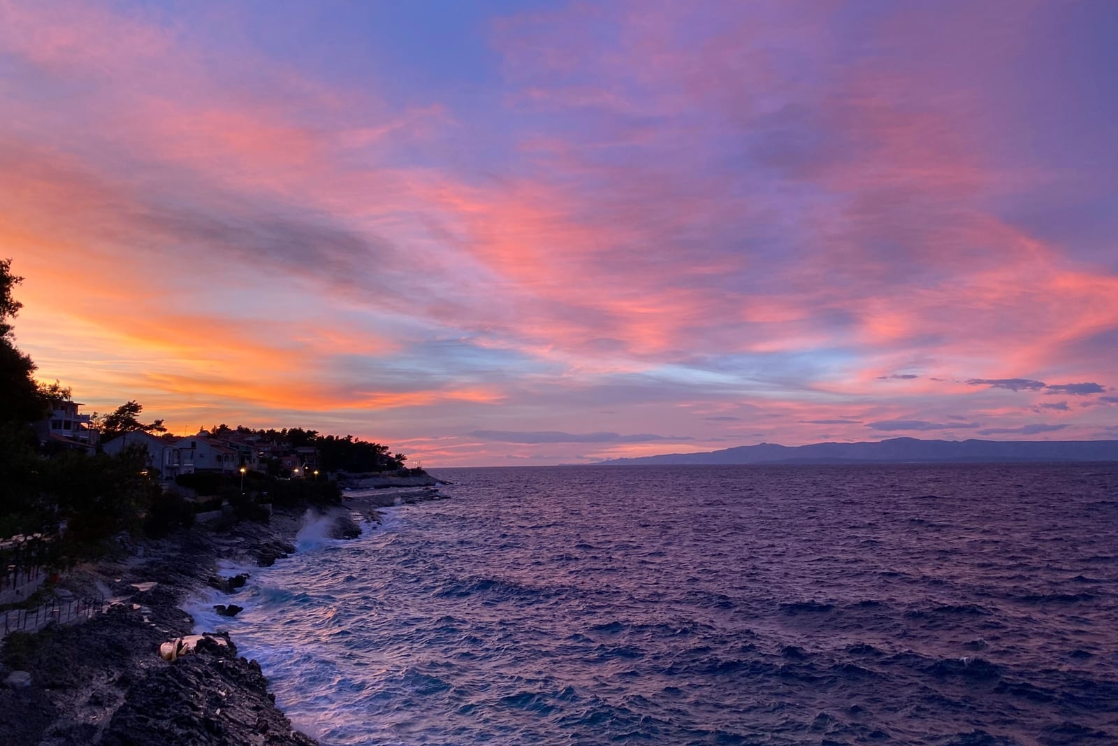 Felsige Kueste und Sonnenuntergang am Meer auf Korcula