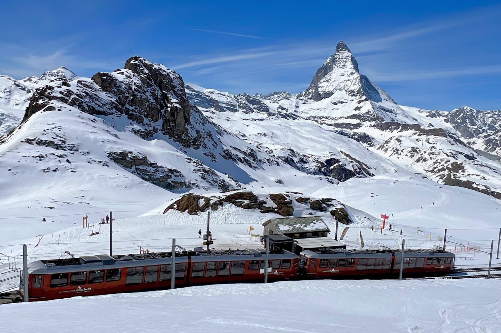 Matterhorn und verschneite Pisten mit roter Bergbahn in Zermatt